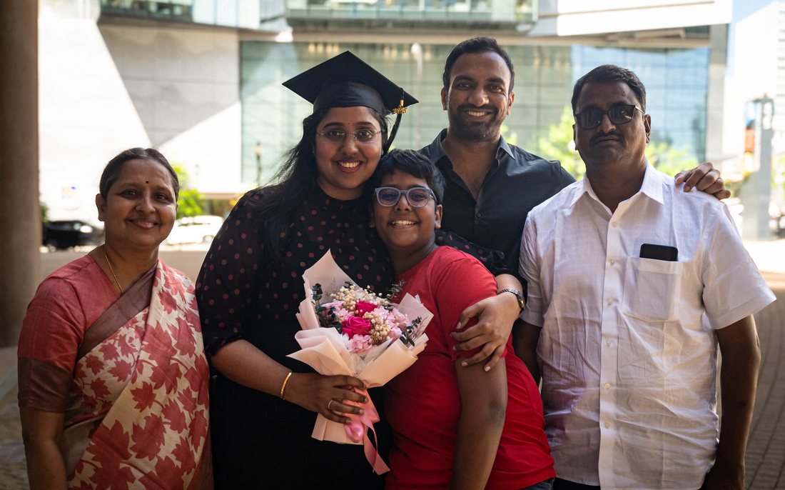 Graduate with her family holding flowers in downtown Vancouver
