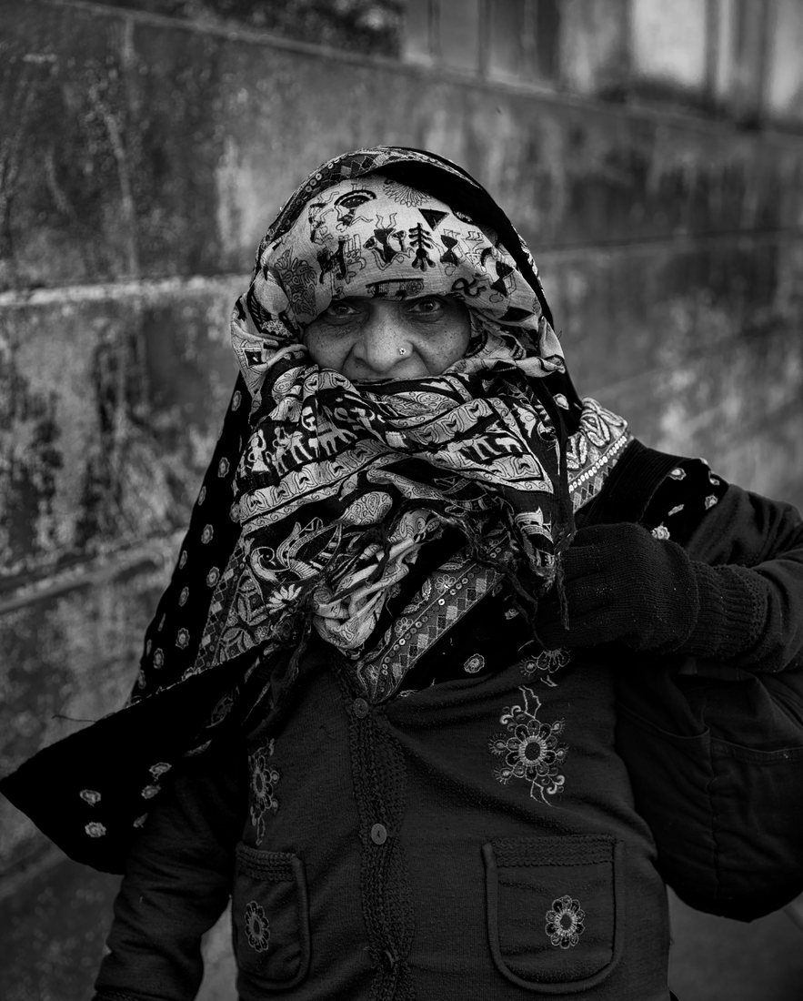 Frontal monochrome portrait of a woman in a patterned headscarf